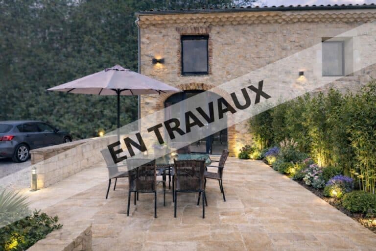 Stone terrace with outdoor table and landscaped garden at the Nid des Mésanges in Provence Drôme