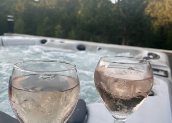 Jacuzzi extérieur avec verre de rosé pour week-end romantique en location saisonnière en Drôme