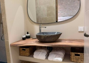 Salle de bain privative avec vasque en pierre et meuble en bois à la Bulle des Mésanges dans la Drôme